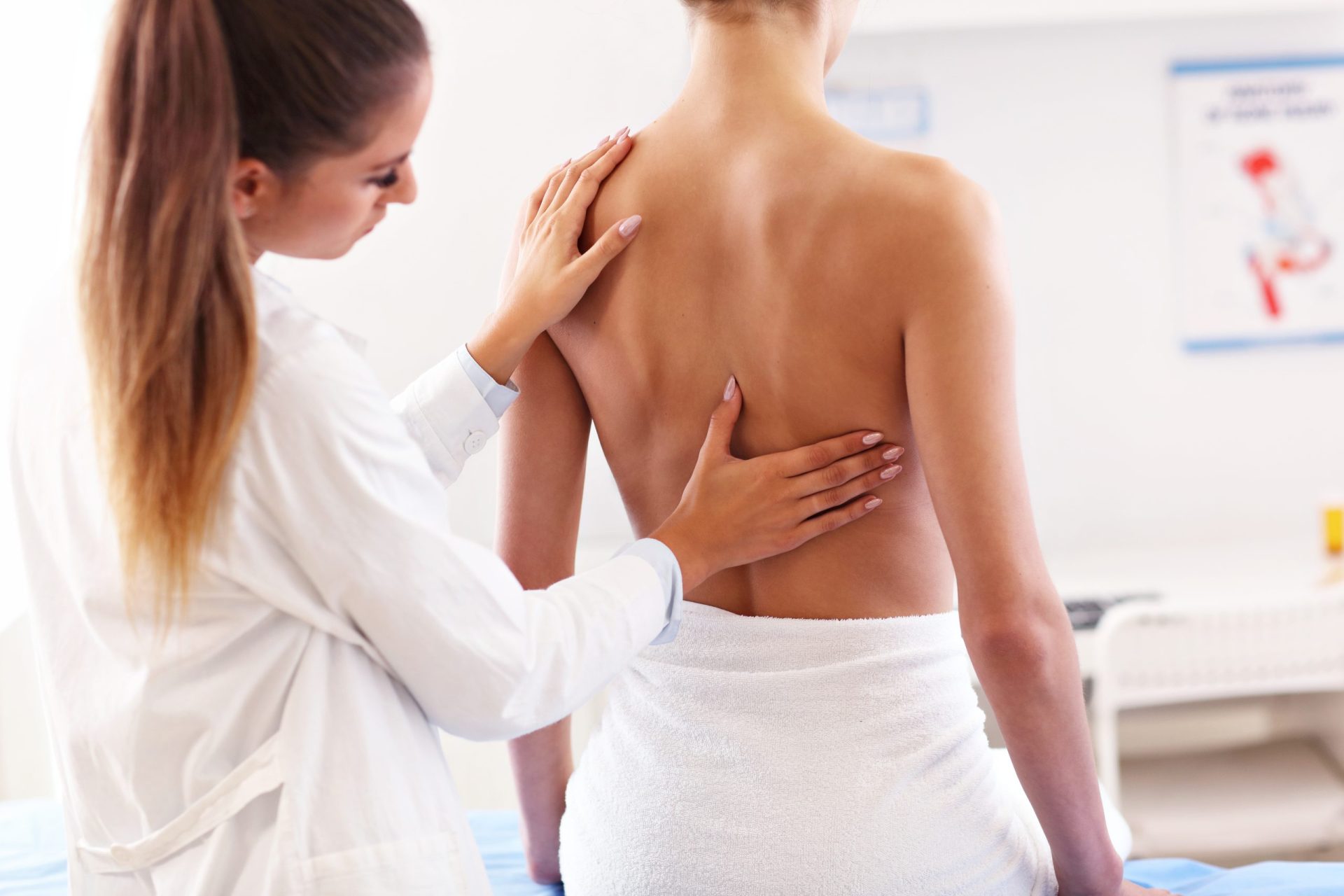 Fisioterapeuta tractant l'esquena d'una pacient